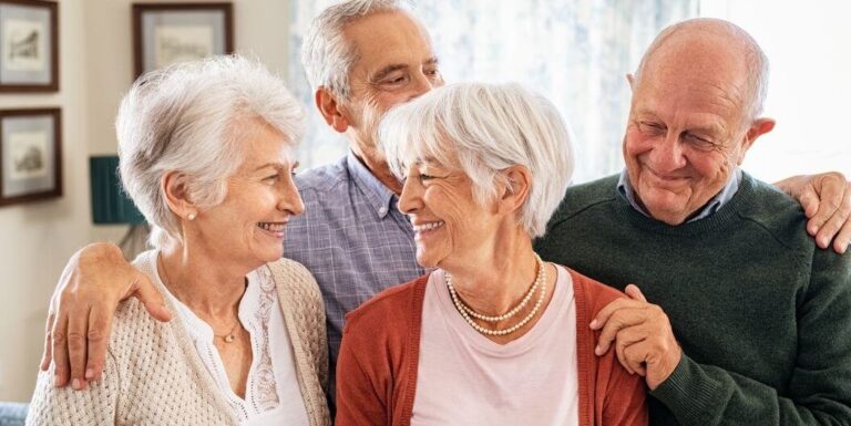 Four Elderly Friends Embracing in Warm Hug at Independent Living Facility